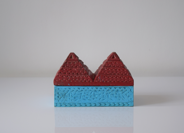 side view of a pyramid box- turquoise base and red pyramid top