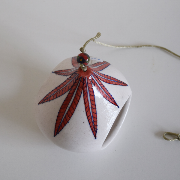 white tea light with red leaf pattern