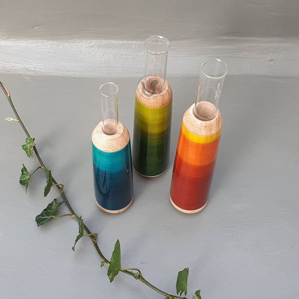 red, green and blue wooden test tube vases