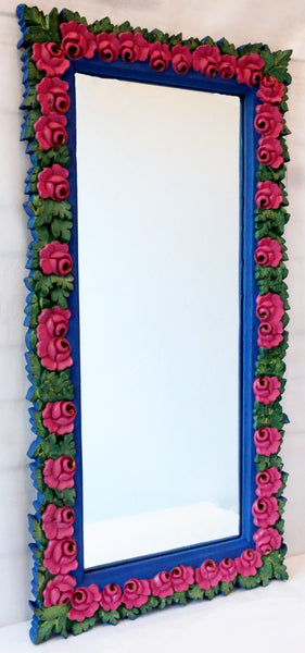 side view of indigo mirror with pink roses all around and green leaves.