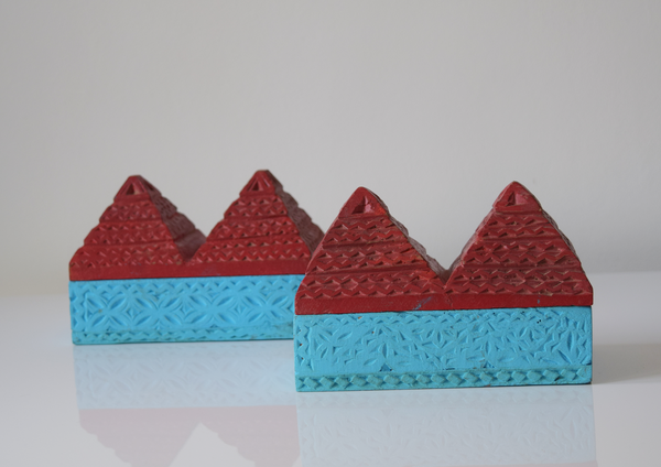 side view of a pair of pyramid boxes- turquoise base and red pyramid top