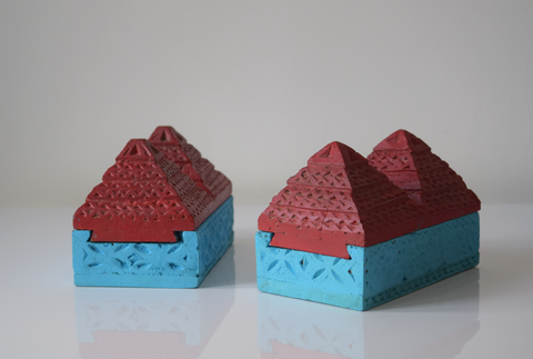 angled view of a pair of pyramid boxes- turquoise base and red pyramid top