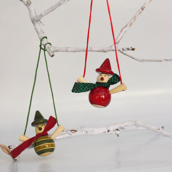 red and green wooden snowmen on a swing ornaments