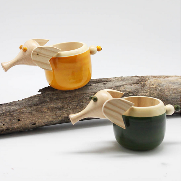 green and yellow wooden elephant pen stands