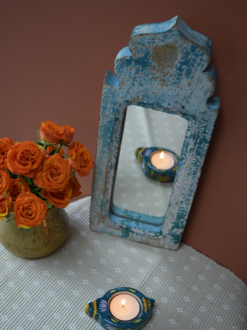 blue distressed dome shaped mirror against rust background